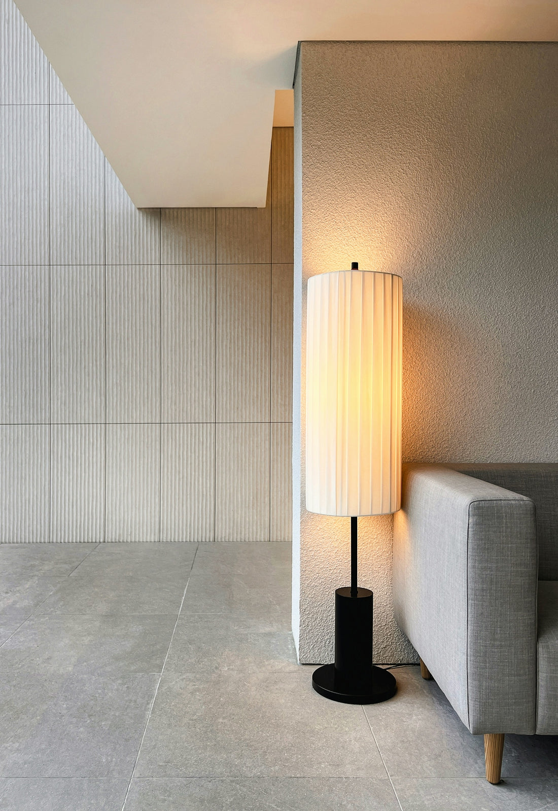 a lamp sitting next to a couch in a room