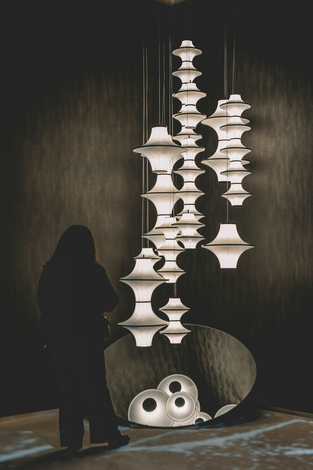 Woman looking at a modern art installation with lamps