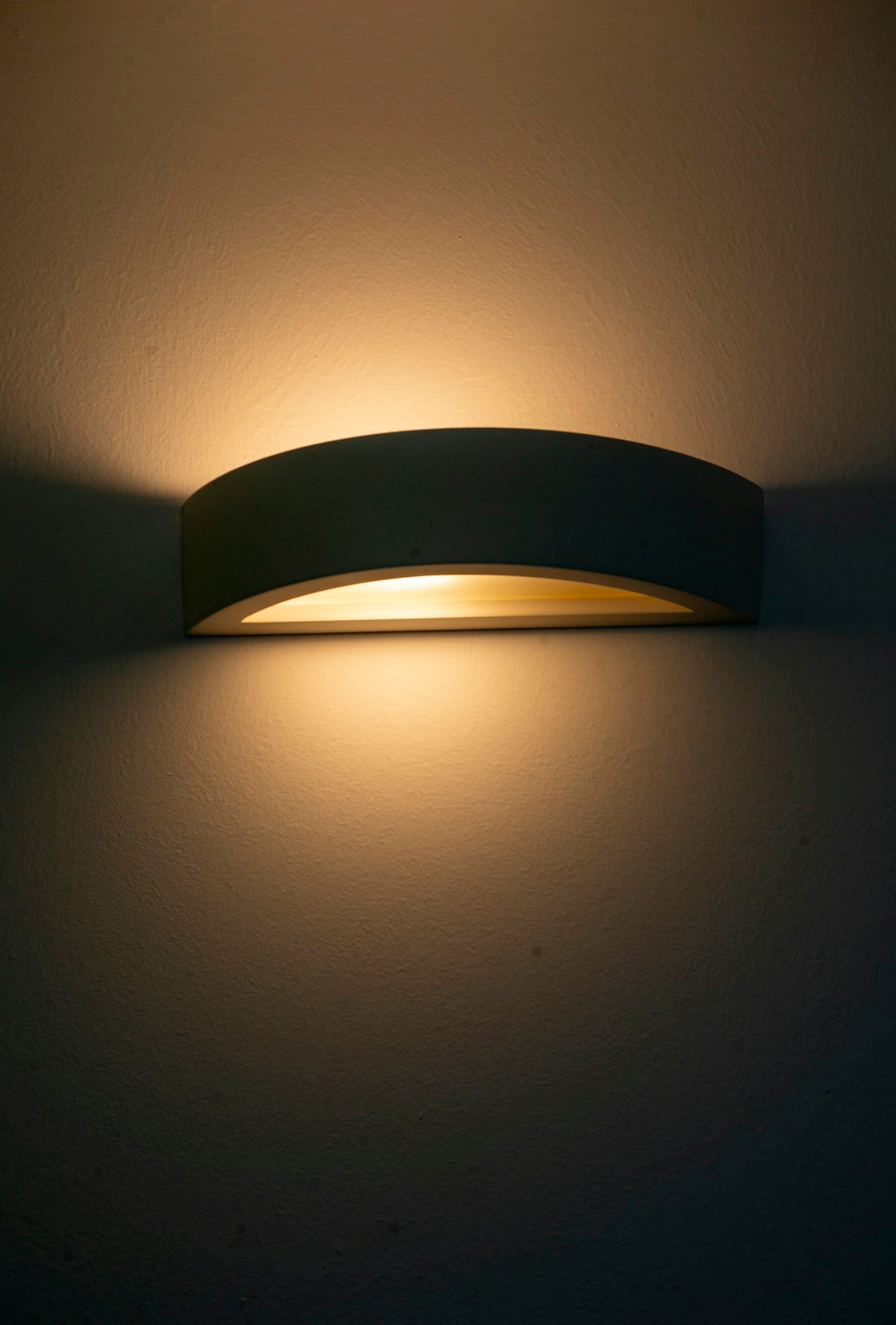 A modern wall sconce emitting warm light